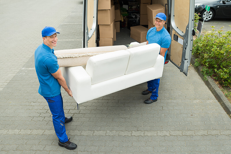 Two movers unloading a couch